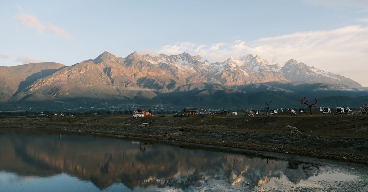 Zibo Travel Guide: Planning Tips, Costs and Things to Do A stunning mountain range reflected in a serene water body during dusk, capturing tranquility and natural beauty.