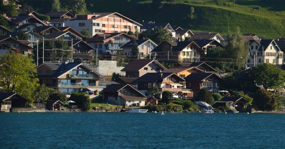 Krone in Sarnen: A Reimagined Swiss Stay with Regional Flavors Idyllic Swiss village by the lake with traditional houses and lush greenery.