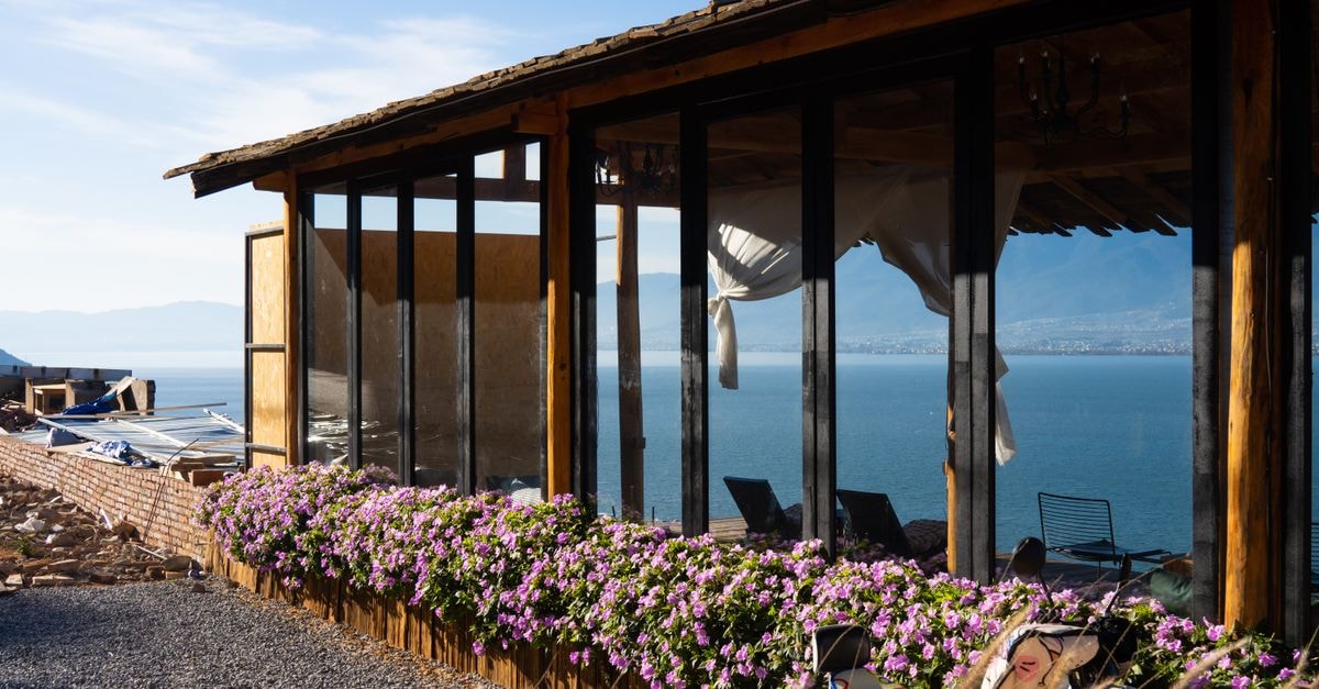 Dali Travel Guide: Slow Days Between Cangshan and Erhai Scenic view of a lakeside house with flowers in Dali, China.