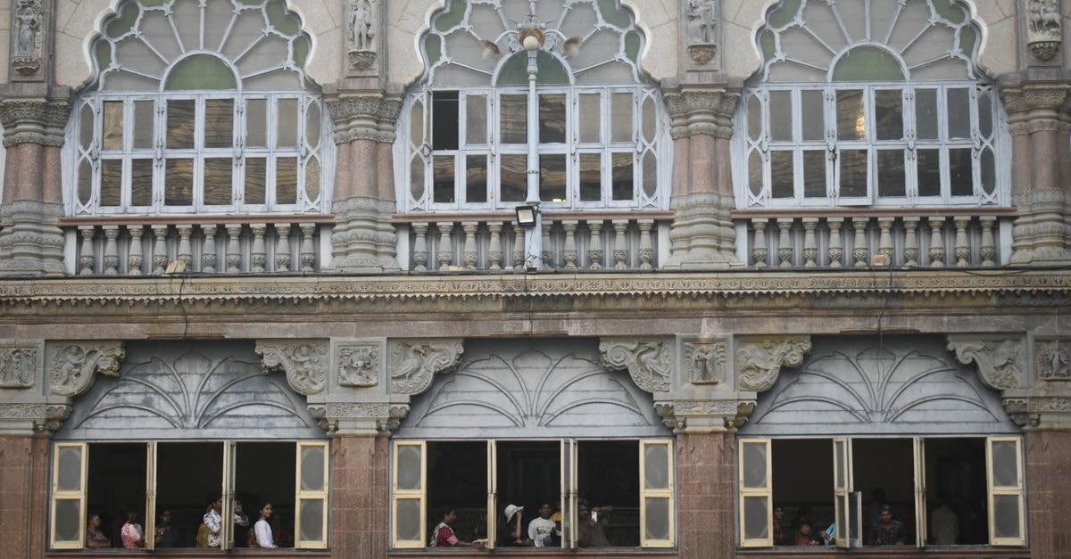 Kolhapur Travel Guide: Heritage, Spice, and Slow Days Close-up of the ornate architecture of Mysore Palace featuring arched windows and visitors peering out.