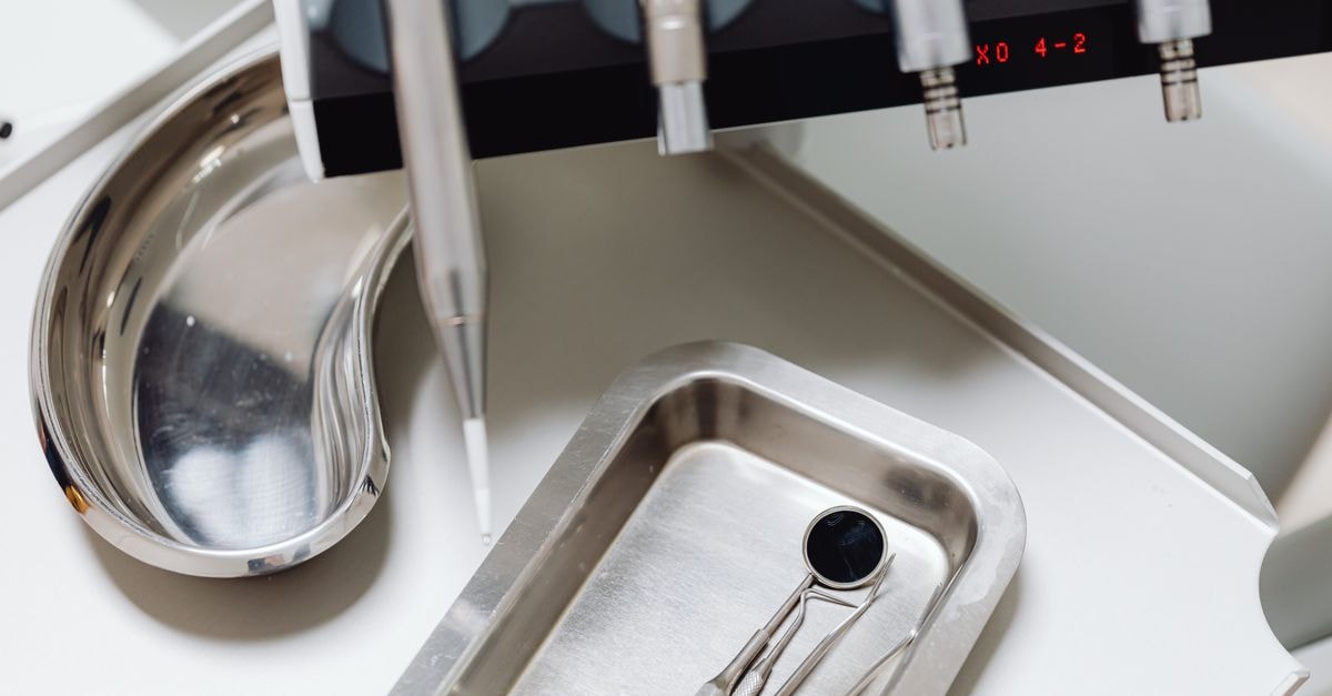 Dental instruments on a silver tray, ideal for illustrating medical and dental themes.