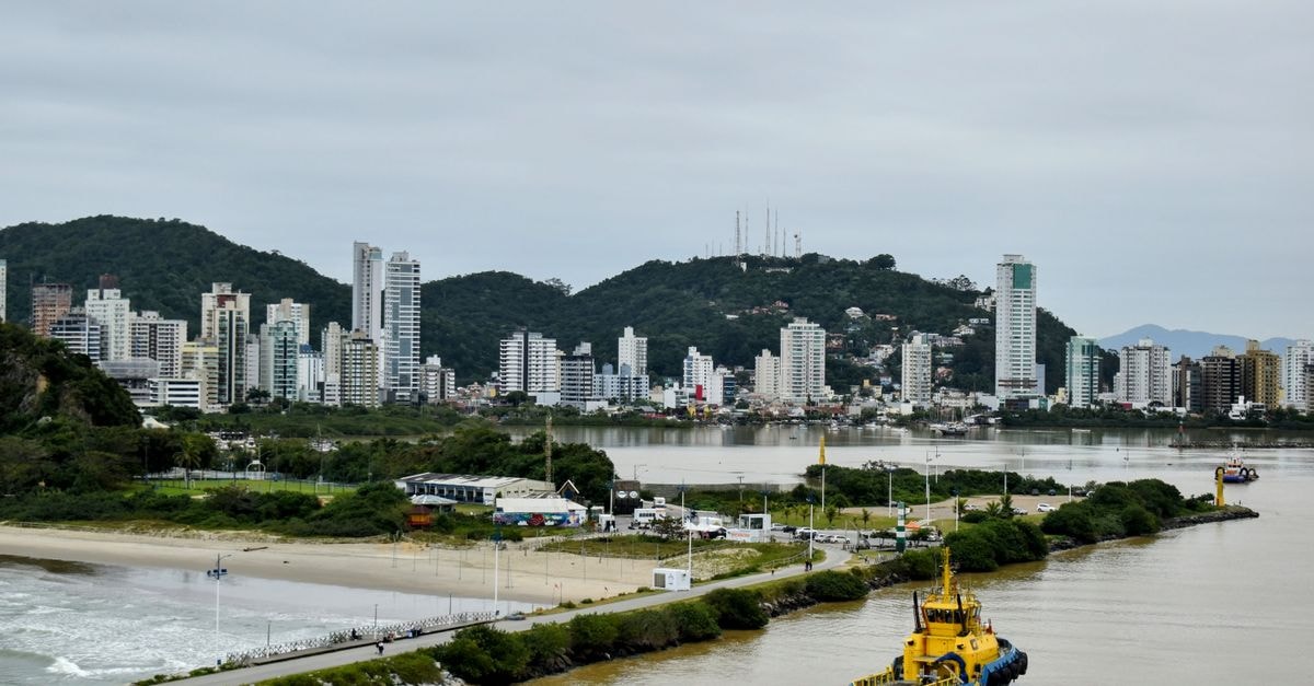 Equatorial Hotel in Macapá: A Practical Stay on Brazil's Equator Line Skyscrapers of Navegantes, Brazil, overlooking a serene harbor with a vibrant yellow tugboat.