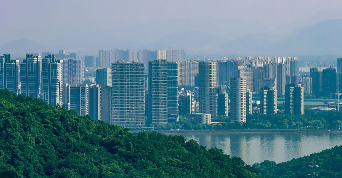 Qingyi Hotel in Taizhou: Luqiao District Address on East Luqiao Avenue Explore the urban skyline contrasted with lush green foothills.