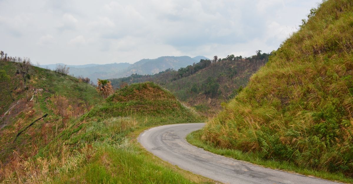 Three J Guesthouse, Kamphaeng Phet — Teak Houses in a Garden A winding mountain road through lush landscapes in Kamphaeng Phet, Thailand.