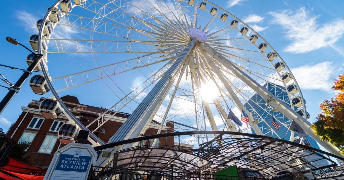 Atlanta Travel Guide: Easy Ways to Explore the City Capture of the SkyView Atlanta Ferris Wheel with blue skies and vibrant sunlight.