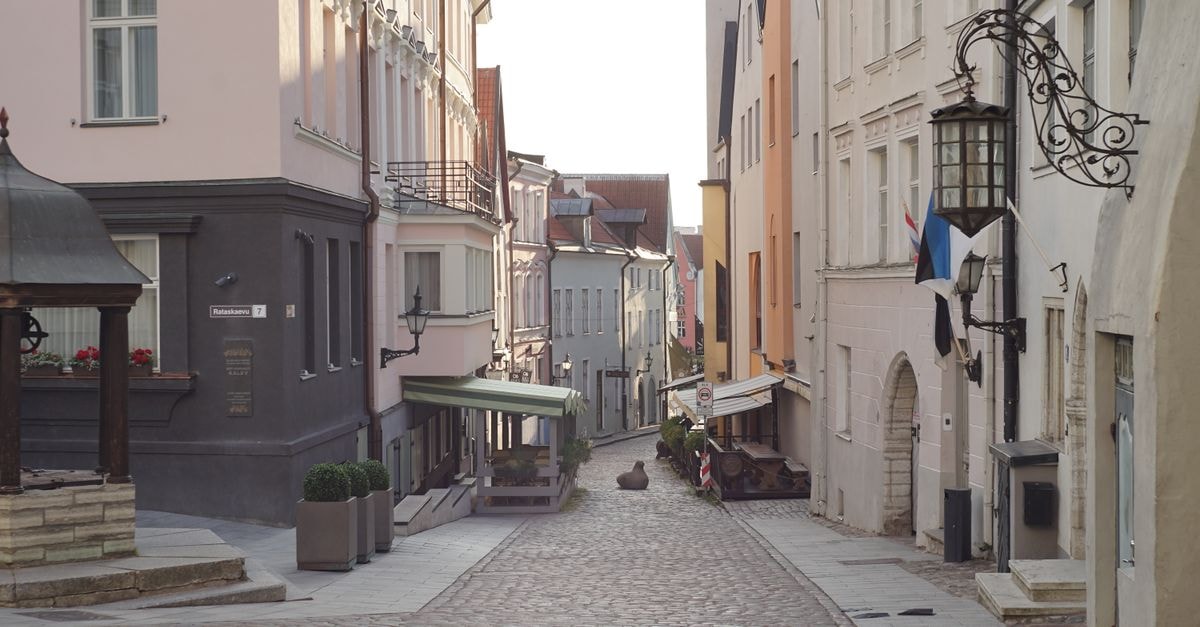 Slow mornings and old streets: a Telšiai travel guide Cobbled street in Tallinn's Old Town lined with historic buildings. Calm, picturesque view.