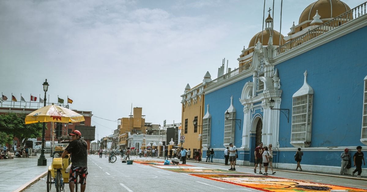 Vibrant Trujillo street with colonial architecture and locals on a sunny day.