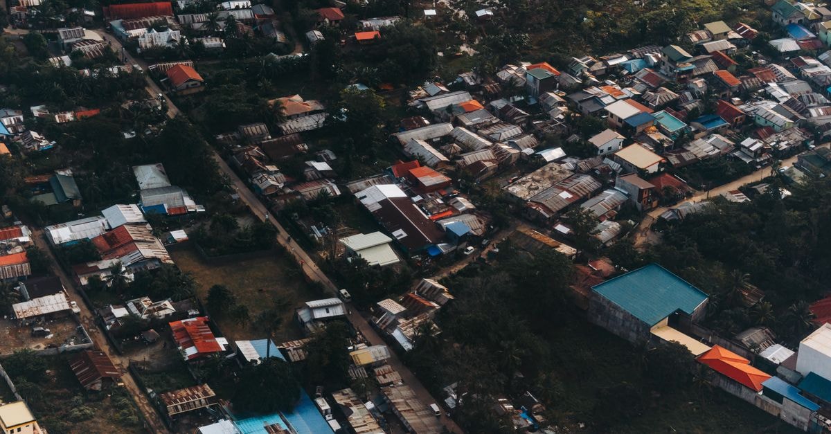 Vibrant aerial view capturing a densely built urban area with colorful rooftops and greenery.