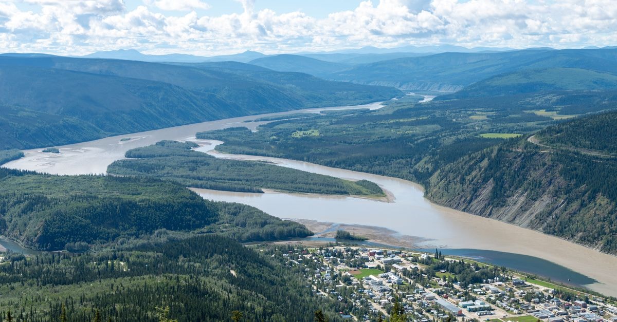 Whitehorse Travel Guide: A Northern Capital at an Easy Pace A breathtaking aerial shot of Dawson City, Yukon, Canada with the scenic Yukon River winding through lush green valleys.