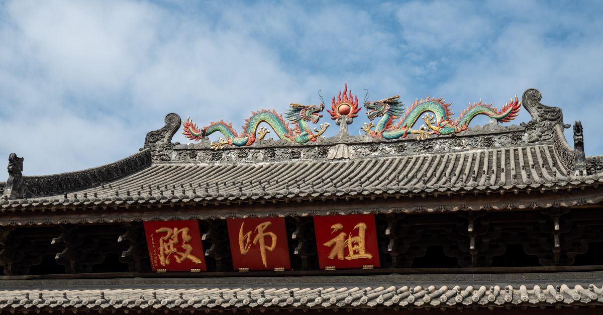 《龍族世家》帶動 HBO Max 排名,觀看量飆升 46% 古樸中式廟宇屋頂上華麗的龍形雕塑與紅色幡旗,在晴朗的藍天下。