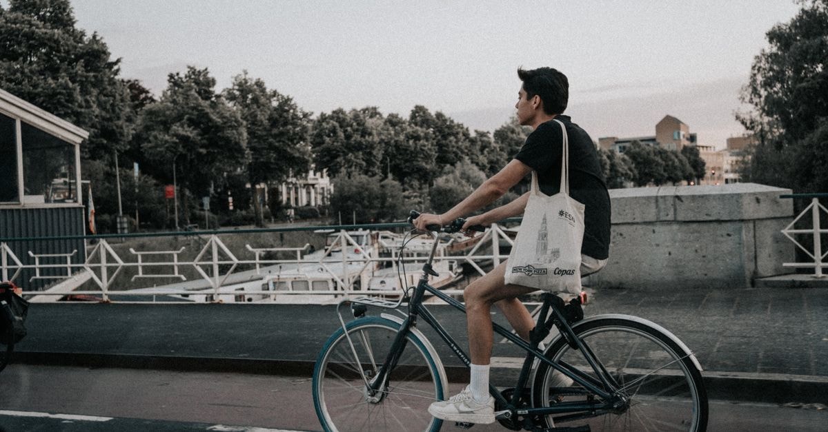 A young man rides a bicycle along a canal in Groningen, Netherlands.