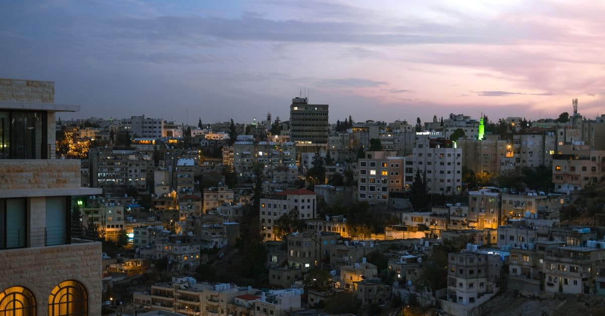 Cliff Hotel, Amman: A Backpacker Landmark Downtown Beautiful evening skyline view of Amman, Jordan with illuminated residential buildings.