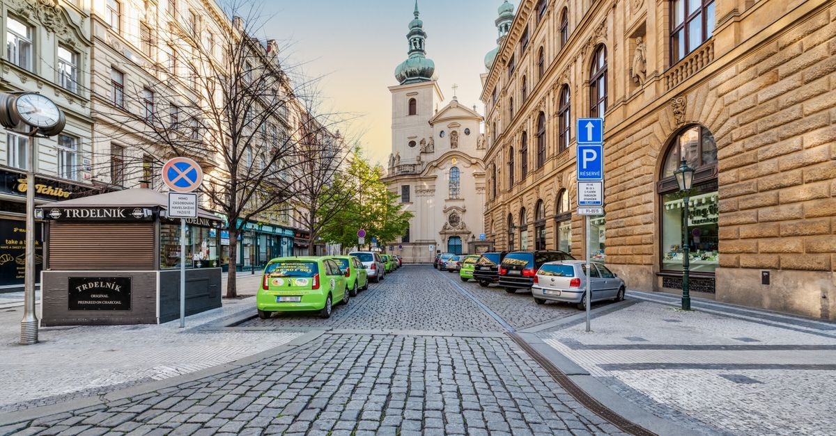 Beautiful cobblestone street in Prague with view of St. Havel Church under blue sky.