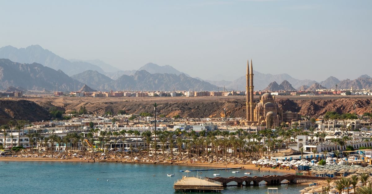 A stunning aerial view of Sharm El Sheikh featuring the coastline and city landmarks against a mountainous backdrop.
