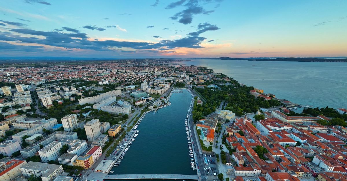 A breathtaking aerial shot of Zadar, Croatia, capturing the city's coastal beauty and vibrant skyline at sunset.