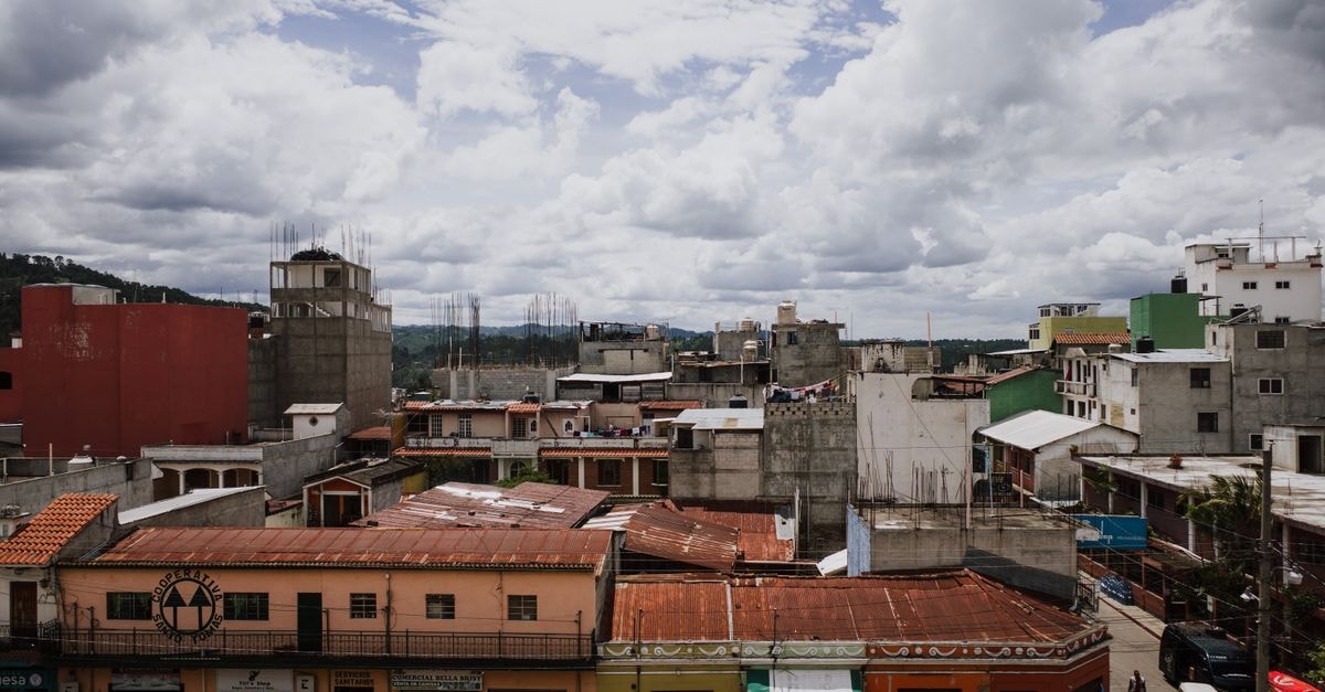 Hotel El Arabe in Xalapa: A Bright Stop in the Pomona Neighborhood A vibrant urban cityscape showcasing colorful rooftops in Chichicastenango, Guatemala with dramatic clouds above.