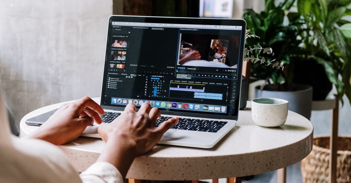 Adobe Releases Premiere Early Access Beta for Android, Raising Googlebook Optimization Questions Freelance video editor working on a laptop in a cafe setting, utilizing Adobe software.