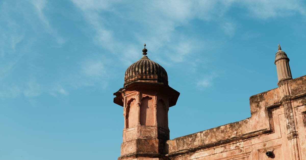 Darbhanga travel guide: heritage, holy grounds, and honest local flavor Close-up of a historic architectural structure with ornate detailing against a bright blue sky.