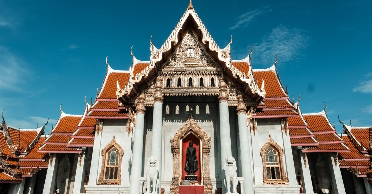 Beautiful facade of Wat Benchamabophit, showcasing traditional Thai architecture under a clear blue sky.
