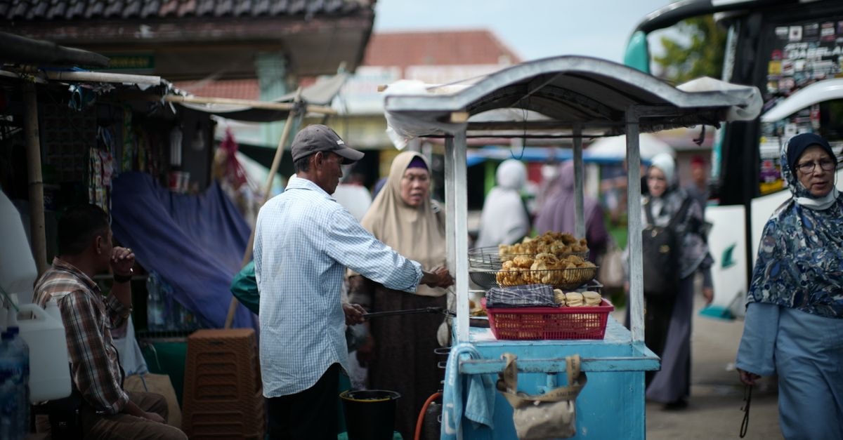 Bustling street food market in Jakarta with vendors and locals engaging in daily commerce.