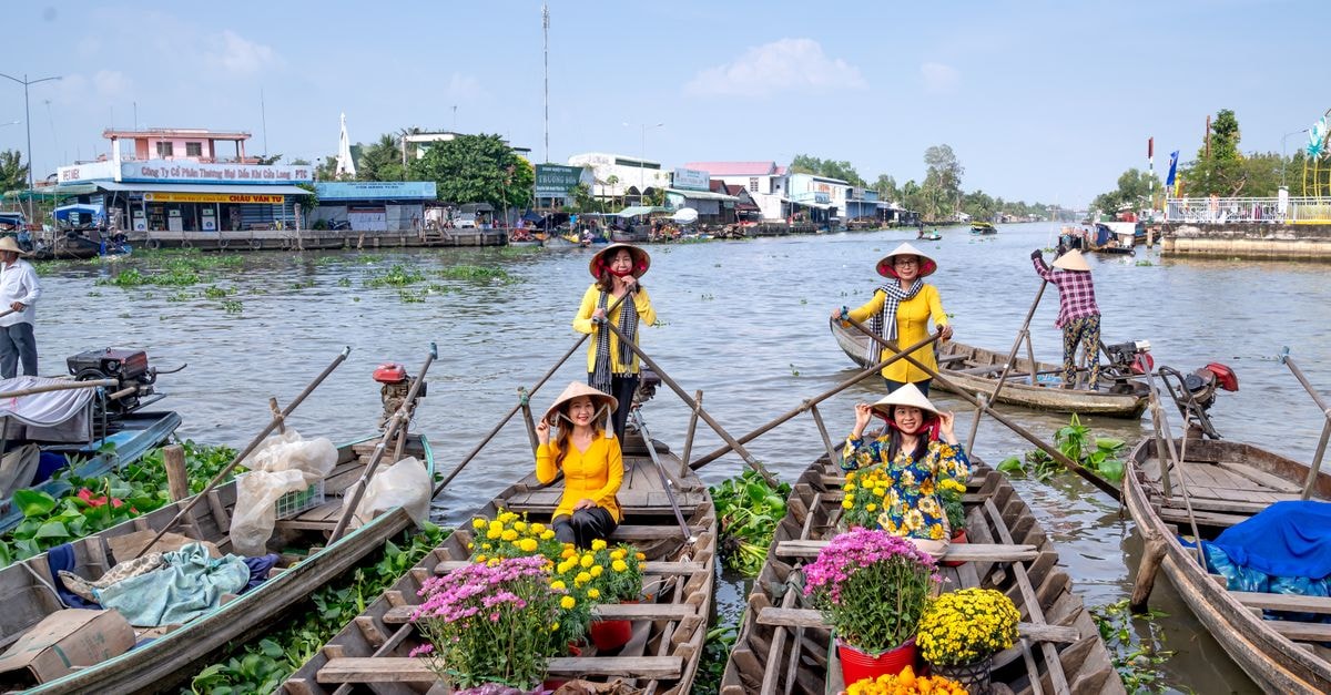 Can Tho Travel Guide: Mekong Delta Memories by the Water Women in traditional hats on a vibrant floating market, showcasing flowers and culture.