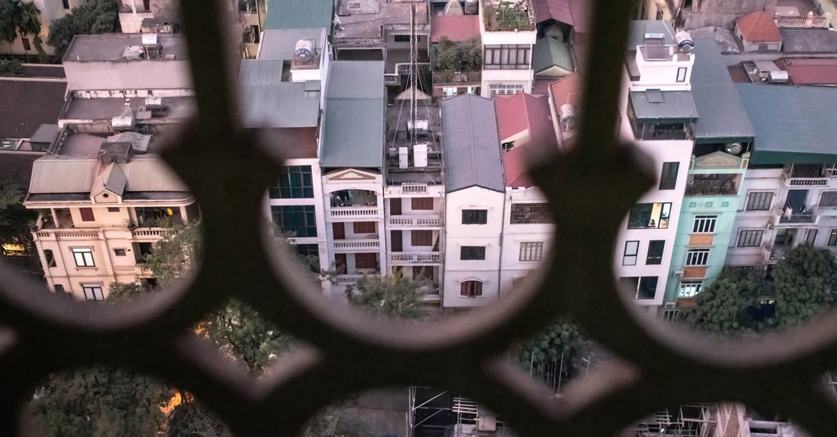 Mango Hotel, Hanoi: A Contemporary Stay Steps from the City Center Elevated view of Hanoi's unique rooftops and urban architecture through a decorative barrier.