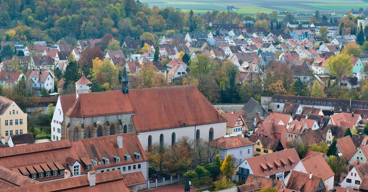A beautiful aerial view of Nördlingen, Bavaria, showcasing red-roofed buildings and autumn foliage.