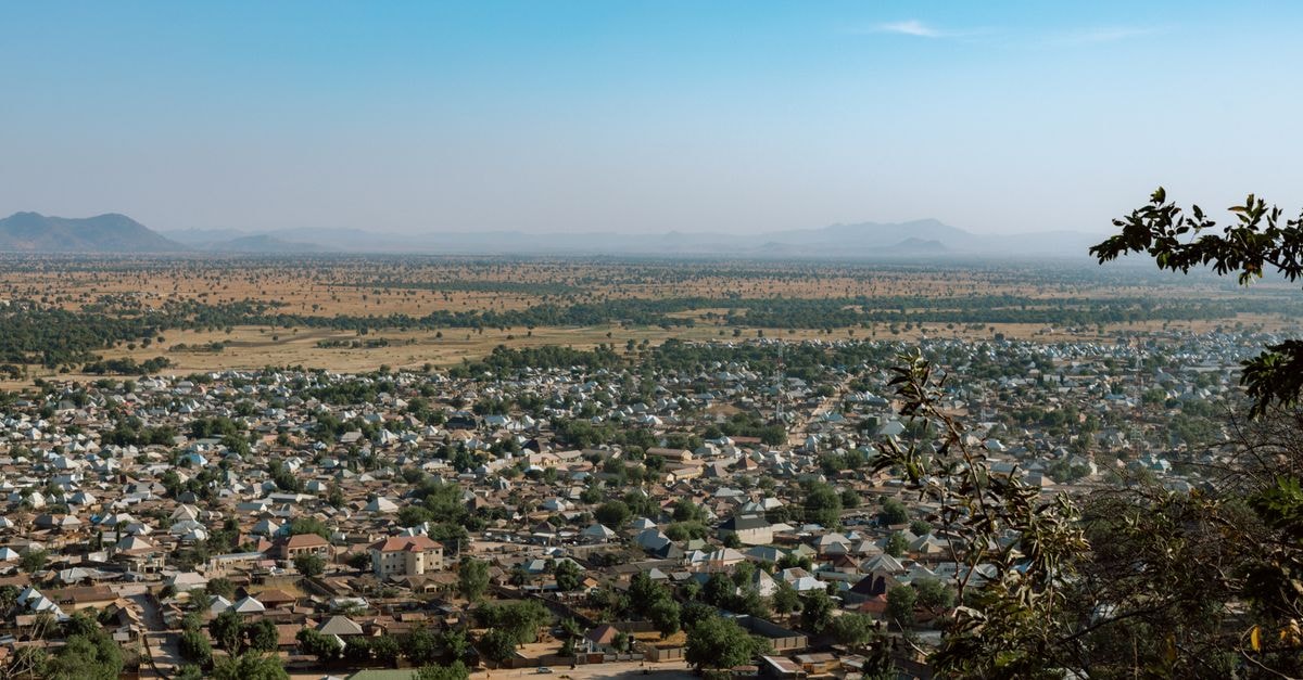 Chez Maman Togo in Abomey-Calavi: A Motel on RN 30 Aerial view of a small town sprawling across a vast, arid landscape under a clear sky.