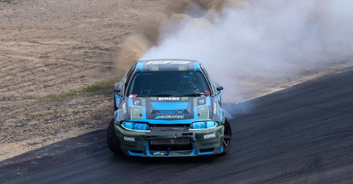 Home Hotel Astoria in Hamar: Central Hub by Lake Mjøsa Capture the thrill of a high-speed car drift with a dramatic smoke trail on a racing track.