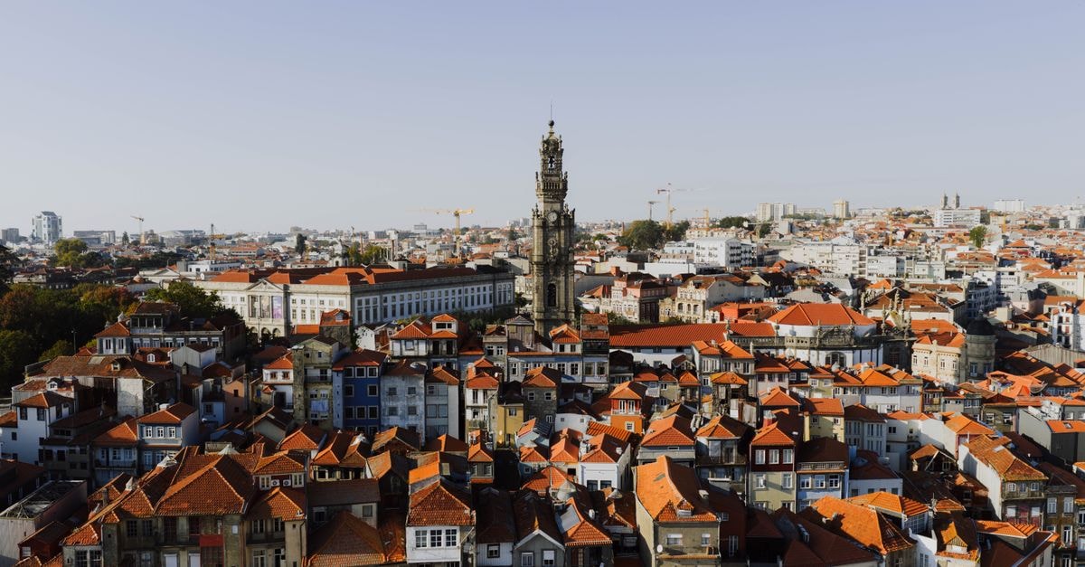 Casa Cavoquinho, Porto Novo — Garden Dinners and Mountain-View Suites A beautiful aerial view of Porto, Portugal, highlighting the iconic Clerigos Tower at sunset.