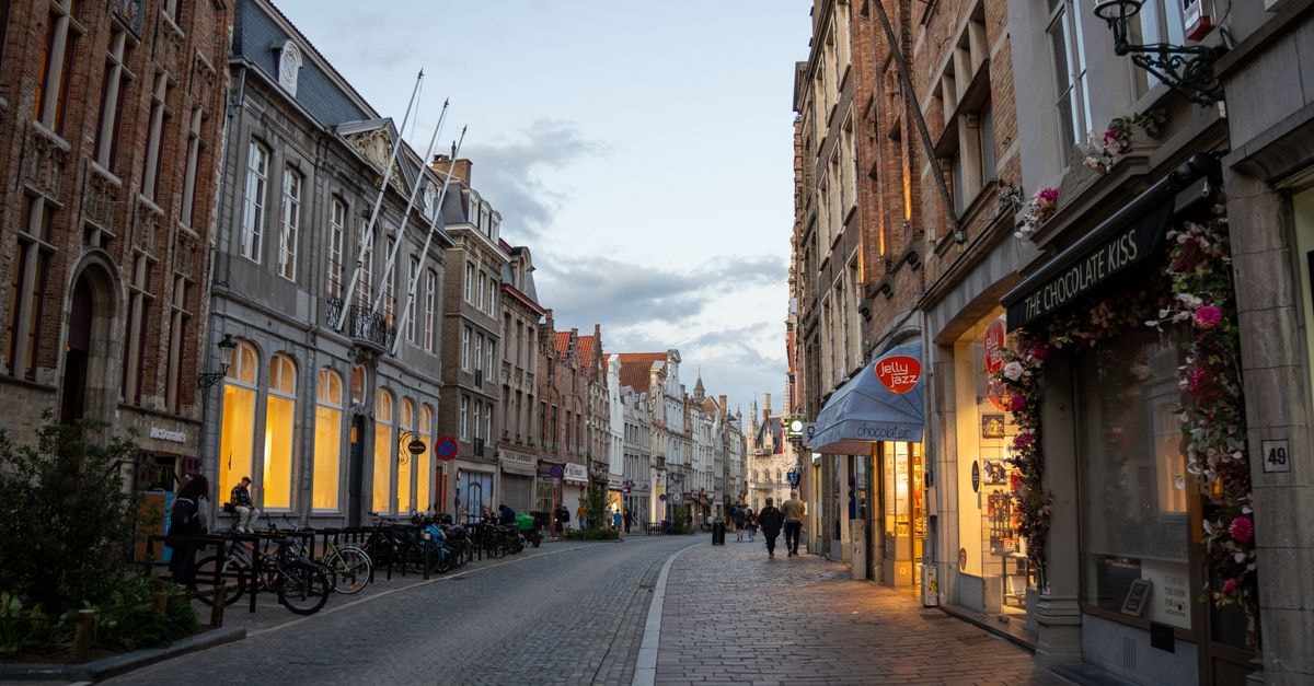 布魯日 Martin's Brugge:入住 Oude Burg 的市中心住宿 比利時布魯日鵝卵石街道的暮色景色,商店與行人更添魅力。