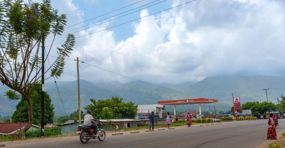 Iringa Travel Guide: Climate, Travel Routes, and Local Rhythm Lively street scene in Uganda with motorcycles and distant hills. Captures local life.