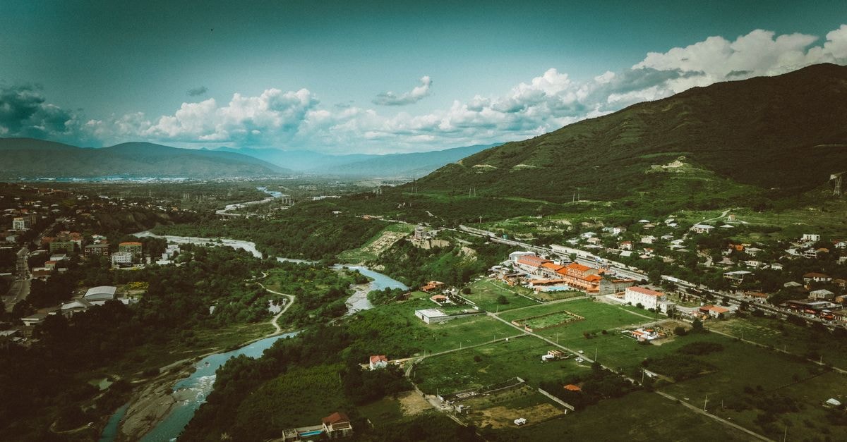 Gjakova Travel Guide: Planning Tips, Costs and Things to Do Scenic aerial shot of a verdant valley and river in Georgia, showcasing natural beauty.