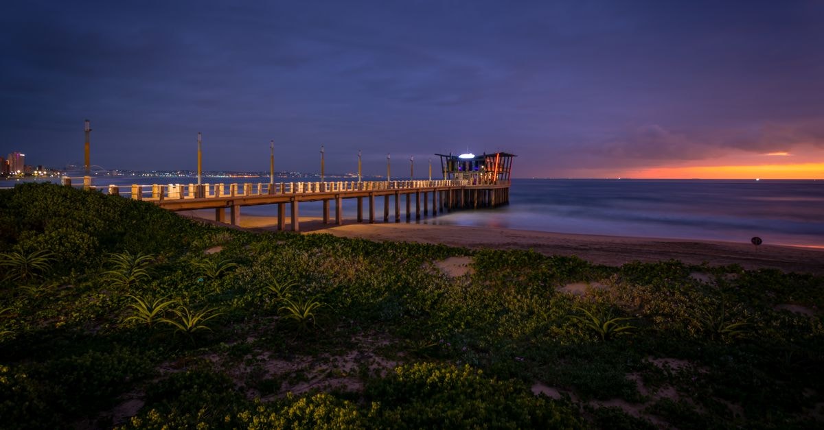 Royal Majestic Durban in Durban — Coastal Calm Near the Beachfront Beautiful sunrise at Durban beach with a vibrant sky, showcasing a picturesque pier and serene ocean.