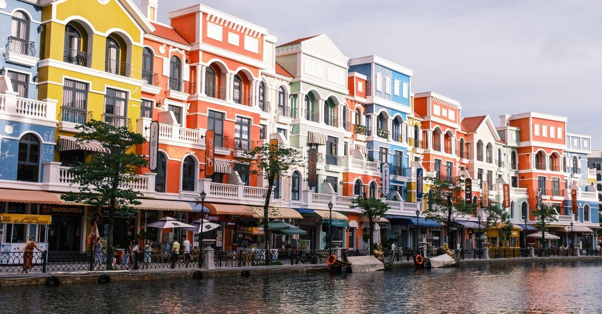Oranjestad Travel Guide: Planning Tips, Costs and Things to Do Colorful Italian-style buildings along a picturesque waterfront, reflecting vibrant architecture.