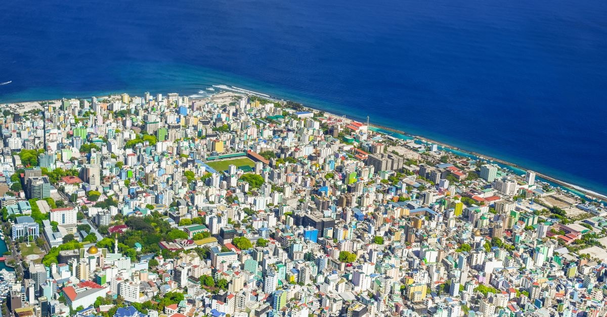Somerset Inn in Malé: A Boutique Budget Stay by the Waterfront Colorful aerial view of Malé, Maldives showcasing cityscape and ocean coastline.