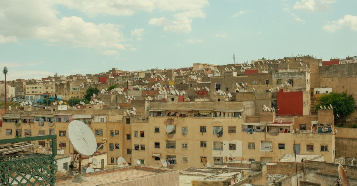 Hotel Hernandarias in Santa Fe: A City-Center Stay by Plaza España Aerial view of the urban landscape in Fes, Morocco, showcasing dense buildings and satellite dishes under a bright sky.