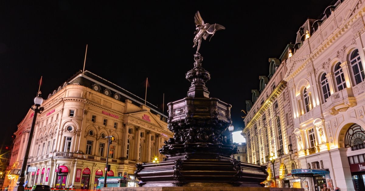 Vibrant nighttime view of the Shaftesbury Memorial Fountain and Eros statue in London's busy Piccadilly Circus.