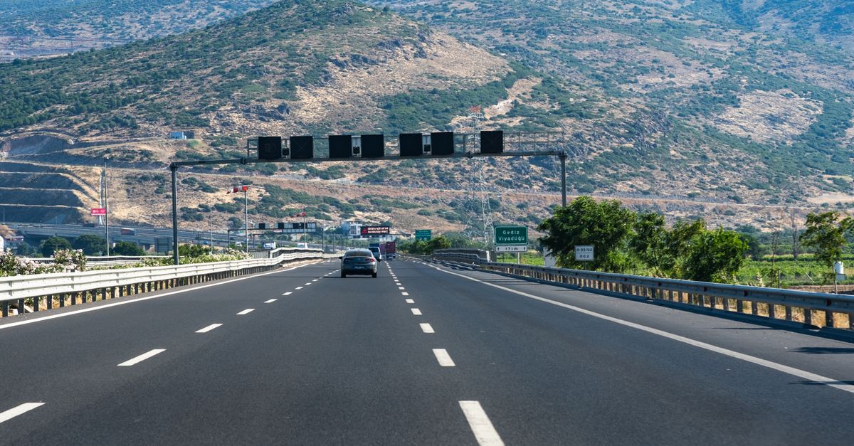 Chania Travel Guide for July 2026: Weather, Transport, Food & Day Trips Long highway with cars traversing through rocky hills under blue skies, perfect travel scene.