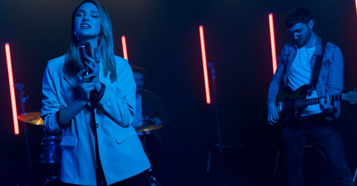Ariana Grande ties Elvis Presley with 25th Hot 100 top 10 as 'Petal' debuts at No. 4 Energetic indie band performing on stage with vibrant neon lighting.