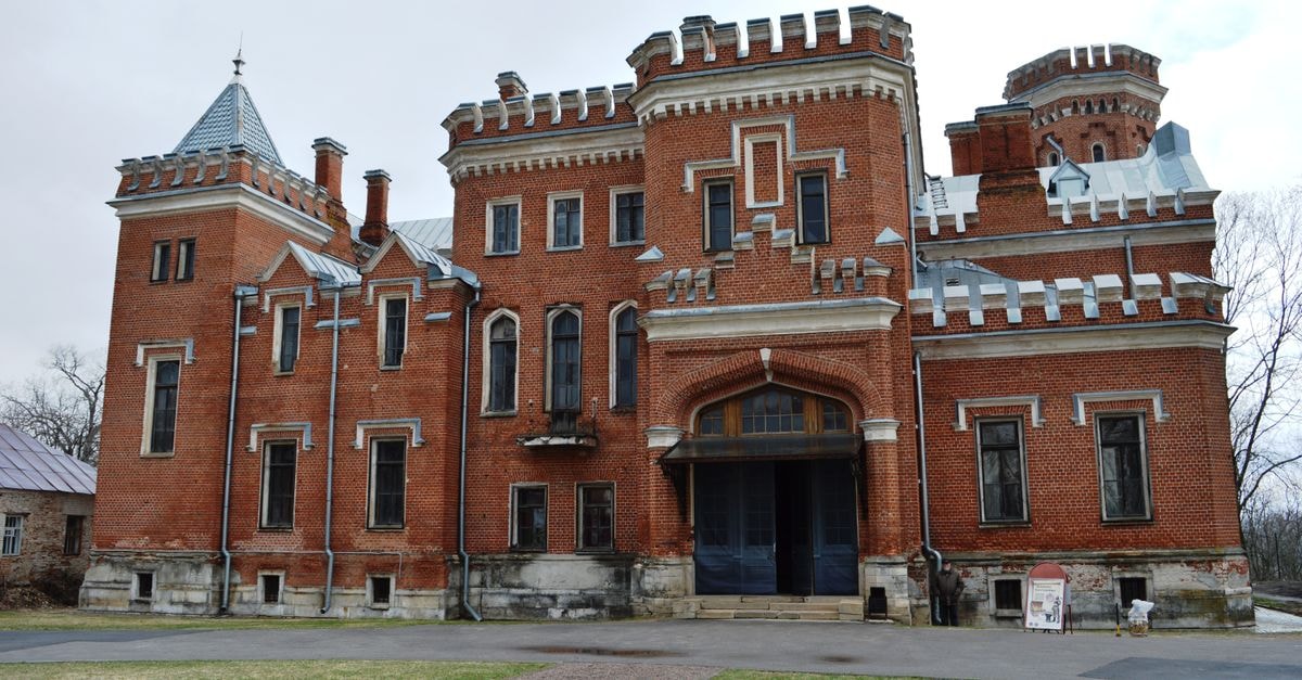 Stunning red brick castle with Gothic features, showcasing historical architecture and design.
