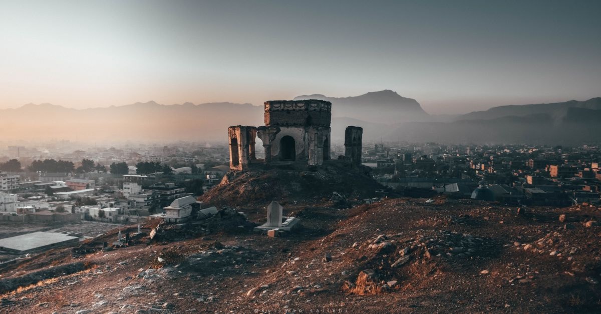 My Home Boys Hostel, Quetta — A Yakhao Stop Near the Railway Tracks Scenic view of ancient ruins and cityscape with mountains at sunset.