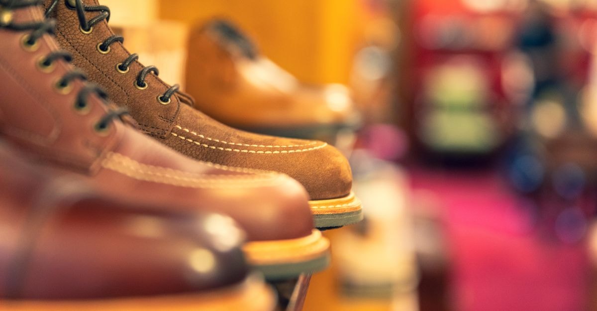 Genesco Inc.: Mid-Year Check on a Specialty Footwear Operator Stylish leather boots on a shelf, showcasing craftsmanship in a shoe store.