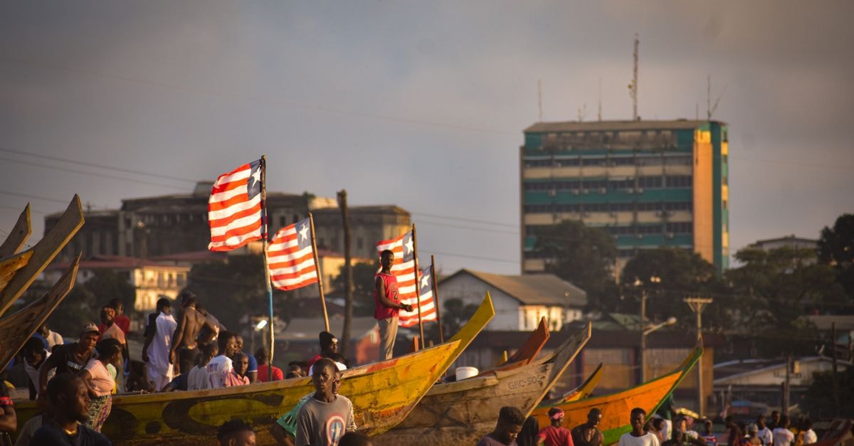 Visiting Monrovia: An Evergreen Travel Guide to Liberia's Capital Vibrant scene of fishermen and canoes along the Monrovia coast during day.