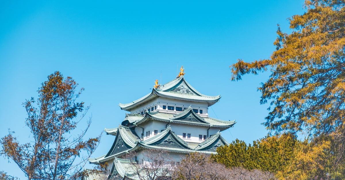 A picturesque view of Nagoya Castle surrounded by vibrant spring foliage in Japan.