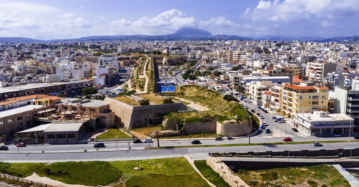 Ibis Styles Heraklion Central: Old-City Stay Near Top Attractions An aerial view of Heraklion, Greece, showcasing the vibrant cityscape blending modern buildings with ancient fortifications.