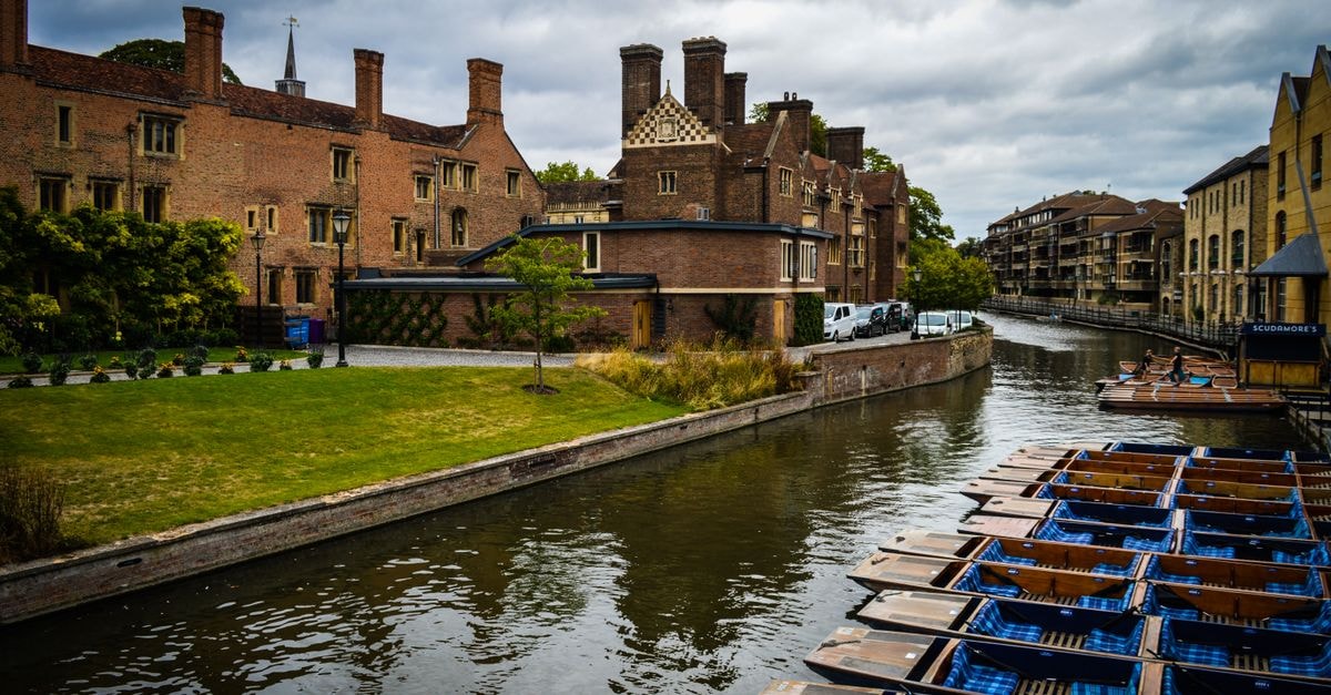 Scenic view of the River Cam with punts and historic architecture in Cambridge, UK.