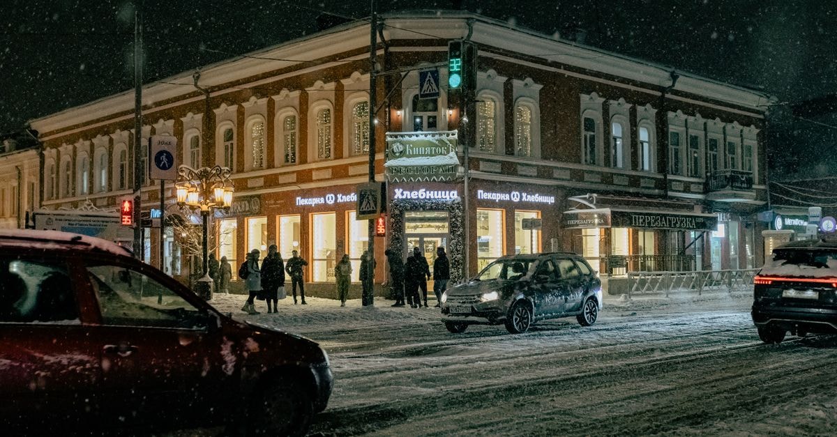 Irkutsk travel guide: getting around and eating well A bustling snowy street at night with cars and pedestrians.