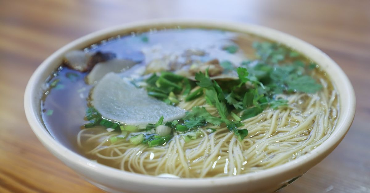 Fuyang at a Glance: A Calm, Food-Led Travel Guide Warm noodle soup garnished with herbs and sliced radish in a ceramic bowl.