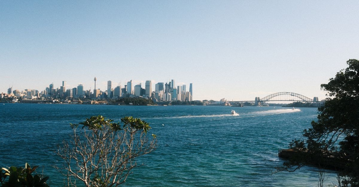 Breathtaking view of Sydney skyline with harbor and famous bridge under a clear blue sky.